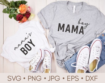May include: Two white t-shirts with black text. One shirt says "mama's boy" and the other says "MAMA boy".