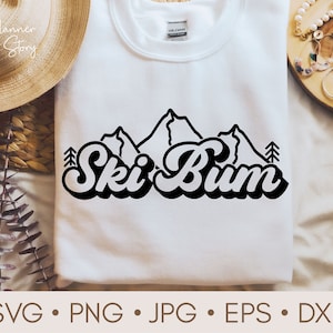 May include: A white t-shirt with a black graphic design of mountains and the text "Ski Bum" in a retro font.