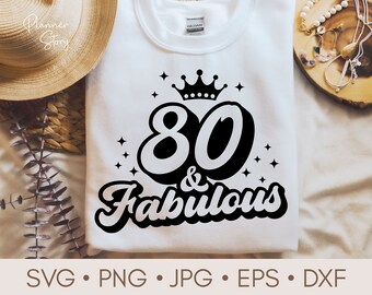 May include: A white t-shirt with a black graphic design that says "80 & Fabulous" with a crown above the number 80.
