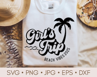 May include: White t-shirt with a black graphic design that says "Girl's Trip Beach Vibes 2025" with a palm tree illustration.