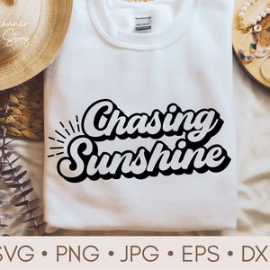 May include: White t-shirt with black text that reads "Chasing Sunshine" in a retro font style.