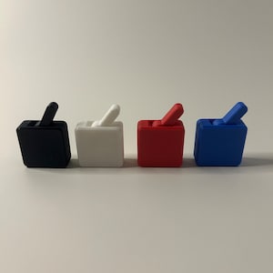 May include: Four small, square boxes with a lever on top. The boxes are black, white, red, and blue.