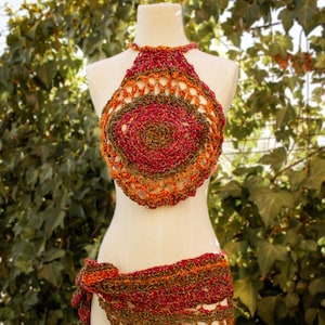 May include: A crocheted halter top and matching skirt in shades of red, orange, and green. The top has a circular design in the center and the skirt is tied at the waist.