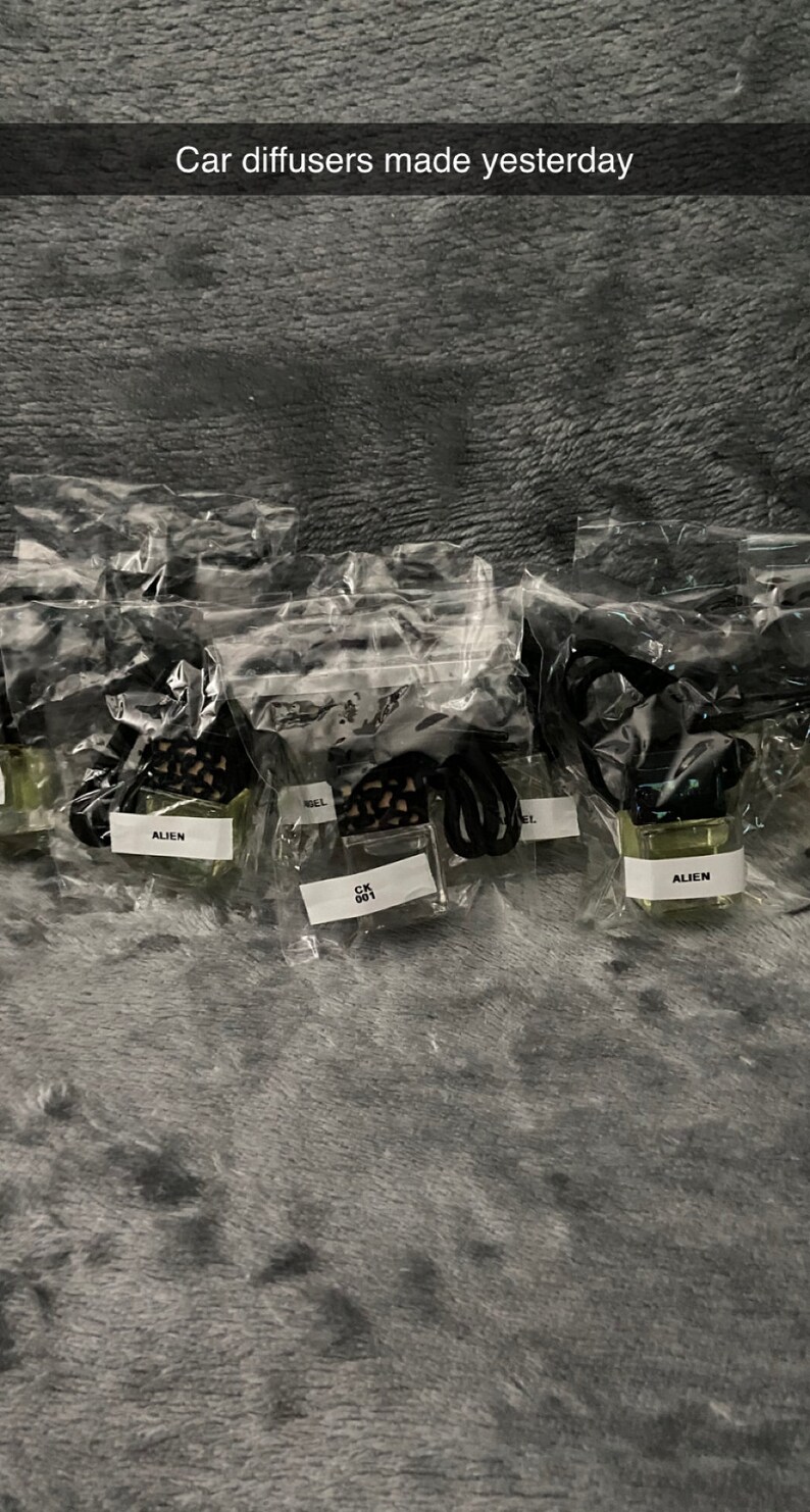 K&ouml;nnte beinhalten: Mehrere kleine Glasflaschen mit schwarzen Deckeln und schwarzen Schn&uuml;ren sind in durchsichtigen Plastikt&uuml;ten verpackt. Die Flaschen sind mit einer klaren Fl&uuml;ssigkeit gef&uuml;llt und tragen Etiketten mit der Aufschrift "Alien" und "CK 001". Der Text "Autodiffusoren, die gestern hergestellt wurden" ist oben im Bild sichtbar.