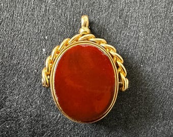 May include: A gold-toned fob seal with a red carnelian stone.
