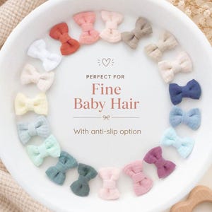 Könnte beinhalten: Eine Sammlung kleiner Haarschleifen aus Stoff in verschiedenen Farben, die kreisförmig auf einem weißen Teller angeordnet sind. Der Text in der Mitte lautet: PERFECT FOR Fine Baby Hair With anti-slip option. Die Schleifen sind rosa, blau, grün und weiß.