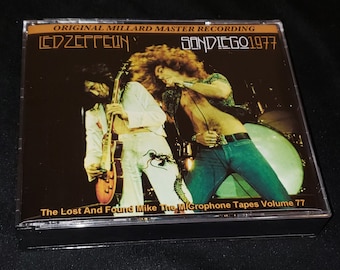 May include: A cassette tape case with a black background and a photo of a band on stage. The text on the case reads "ORIGINAL MILLARD MASTER RECORDING", "LED ZEPPELIN", "SAN DIEGO 1977", "The Lost And Found Mike The Microphone Tapes Volume 77".