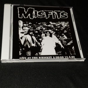 May include: Black and white photo of a band called "Misfits" on a CD case. The band is performing live at the Whiskey a Go-Go on 13.4.82.