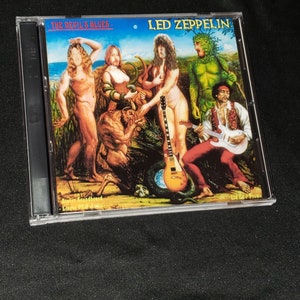 May include: A CD case with a colorful illustration of a band playing music. The case features the text "Led Zeppelin" and "The Devil's Blues".