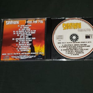 K&ouml;nnte beinhalten: Ein CD-Geh&auml;use mit einem schwarz-wei&szlig;en Bild eines Sch&auml;dels auf der Vorderseite. Das Geh&auml;use ist f&uuml;r das Album "I Feel For You" der Band Samhain. Die Tracklist ist auf der R&uuml;ckseite des Geh&auml;uses abgedruckt.