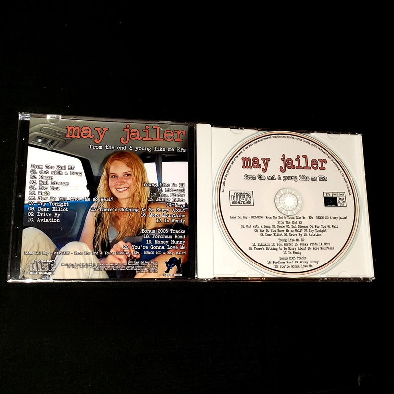 May include: A CD case with a photo of a young woman on the front cover. The CD case is for the album "From the End & Young Like Me EP" by May Jailer. The back of the case lists the songs on the album.