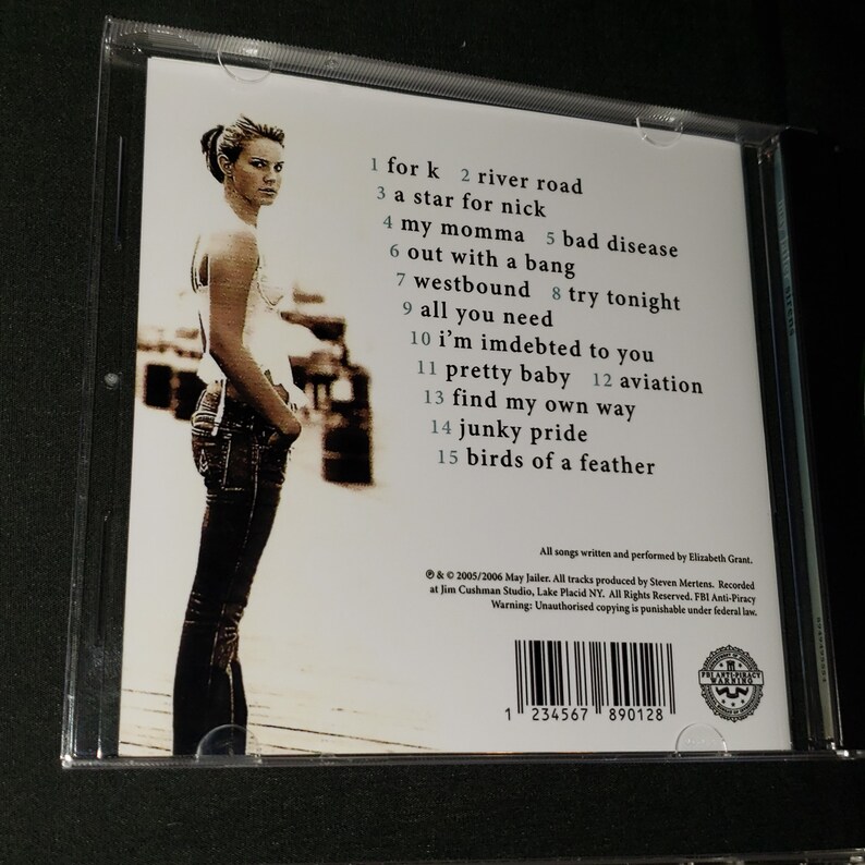 May include: CD case with a white background and a photo of a woman in jeans and a white shirt. The text on the back of the case lists the songs on the album: "for k", "river road", "a star for nick", "my momma", "bad disease", "out with a bang", "westbound", "try tonight", "all you need", "i'm indebted to you", "pretty baby", "aviation", "find my own way", "junky pride", and "birds of a feather".