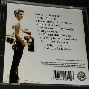 Puede incluir: Una caja de CD con una foto de una mujer en la parte delantera. La parte posterior de la caja enumera los t&iacute;tulos de las canciones: 1 for k, 2 river road, 3 a star for nick, 4 my momma, 5 bad disease, 6 out with a bang, 7 westbound, 8 try tonight, 9 all you need, 10 i'm indebted to you, 11 pretty baby, 12 aviation, 13 find my own way, 14 junky pride, 15 birds of a feather. La caja tambi&eacute;n incluye informaci&oacute;n de derechos de autor y un c&oacute;digo de barras.