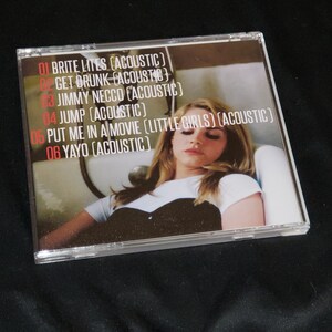 May include: A CD case with a photo of a woman with blonde hair. The CD case has a white background with black text listing the songs on the CD: "01 Brite Lites (Acoustic)", "02 Get Drunk (Acoustic)", "03 Jimmy Necco (Acoustic)", "04 Jump (Acoustic)", "05 Put Me In A Movie (Little Girls) (Acoustic)", "06 Yayo (Acoustic)"