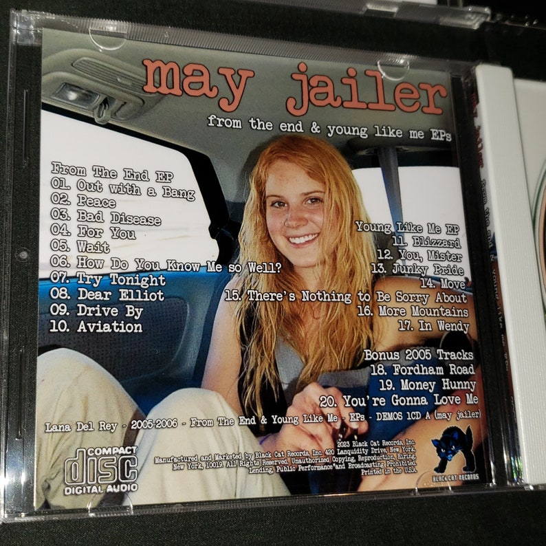 May include: A CD case with a photo of a young woman on the front. The back of the case lists the songs on the CD, including "Out with a Bang", "Peace", "Bad Disease", "For You", "Wait", "How Do You Know Me So Well?", "Try Tonight", "Dear Elliot", "Drive By", "Aviation", "Blizzard", "You, Mister", "Junky Pride", "Move", "There's Nothing to Be Sorry About", "More Mountains", "In Wendy", "Fordham Road", "Money Hunny", and "You're Gonna Love Me". The text "Lana Del Rey - 2005-2006 - From The End & Young Like Me EPs - DEMOS ICD A (may jailer)" is printed at the bottom of the case.