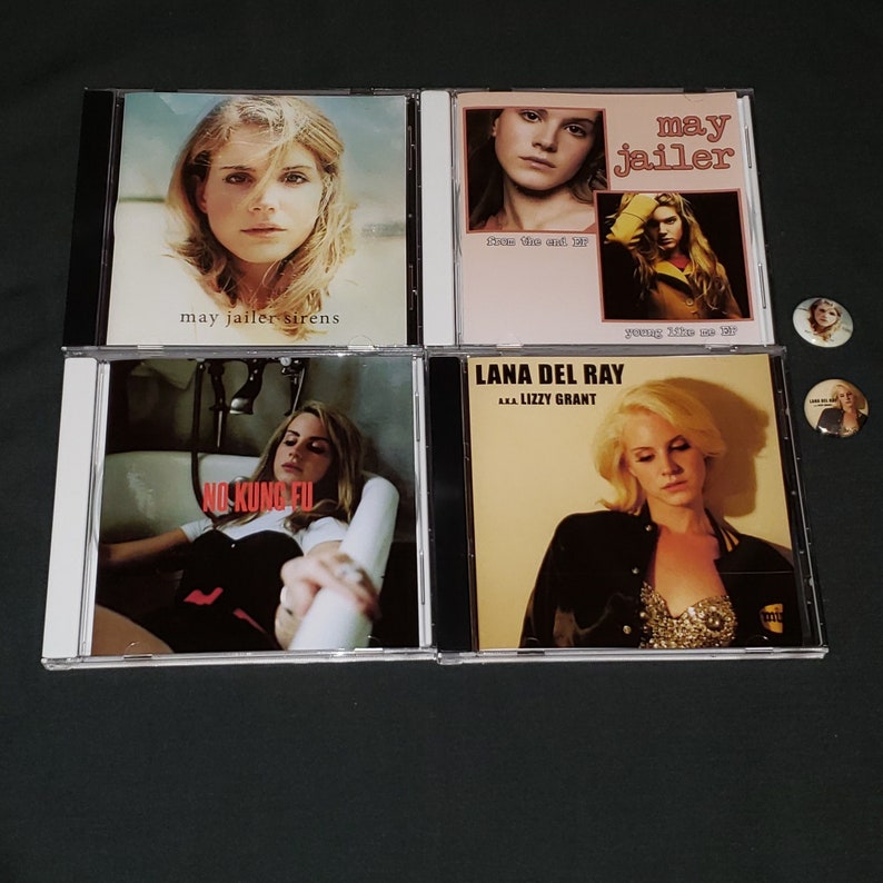 May include: Four compact discs with album covers featuring a woman with blonde hair. The album covers are titled "may jailer sirens", "may jailer young like me EP", "LANA DEL RAY AKA LIZZY GRANT", and "NO KUNG FU".