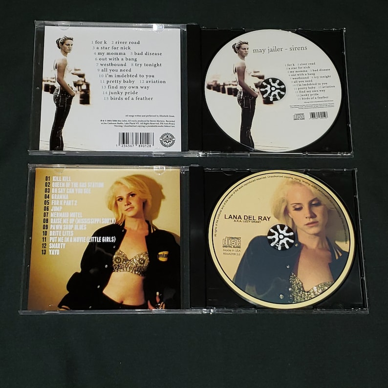 Puede incluir: Dos estuches de CD con fondo negro y una foto de una mujer en la parte delantera. Los estuches de CD son para el &aacute;lbum "Lana Del Ray" de Lana Del Ray. La portada del &aacute;lbum presenta una foto de Lana Del Ray con una chaqueta negra y un sujetador brillante. El estuche de CD de la izquierda tiene una lista de canciones en la parte posterior. El estuche de CD de la derecha tiene el t&iacute;tulo del &aacute;lbum y el nombre del artista en la parte delantera.
