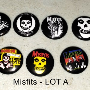 May include: A set of seven Misfits band pinback buttons. The buttons feature various images of the band's logo, including a skull with a black background, a skull with a yellow background, and a skull with a red, orange, and yellow background. The buttons also feature the band's name in black and white text.
