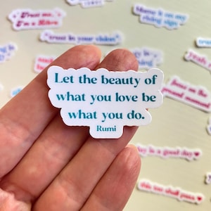 May include: A white sticker with a teal blue quote that reads "Let the beauty of what you love be what you do." The quote is attributed to Rumi.