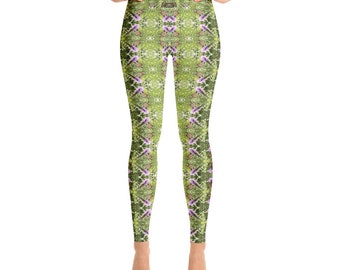 Puede incluir: Leggings de yoga verdes con un estampado floral con flores moradas y hojas verdes. Los leggings tienen cintura alta y una silueta ajustada.