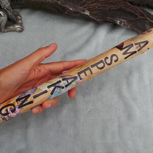 May include: A cylindrical wooden talking stick featuring a natural light wood grain finish. The surface is decorated with a colourful floral pattern and the black text I AM SPEAKING printed in a bold, sans-serif font along the length of the object.