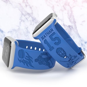 May include: Two blue silicone Apple Watch bands with hockey-themed designs. One band features a hockey player, flames, and a puck. The other band has the name "NATHAN" and the number "15" printed on it.