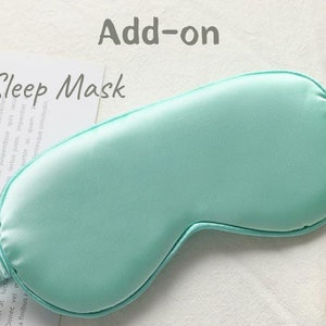May include: A light blue silk sleep mask with an elastic band. The mask is designed to block out light and promote sleep.