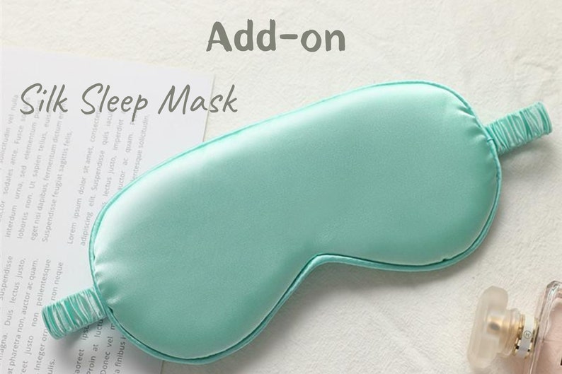 May include: A light blue silk sleep mask with an elastic band. The mask is designed to block out light and promote sleep.