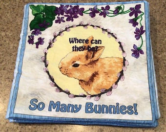 May include: A children's book with a blue and yellow cover. The cover features a picture of a brown bunny rabbit with the text "Where can they be? So Many Bunnies!"