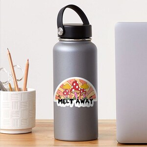 K&ouml;nnte beinhalten: Ein Aufkleber mit einem Retro-Design von roten und wei&szlig;en Pilzen, gelben Wolken und einem regenbogenartigen Hintergrund. Der Text "Melt Away" befindet sich unter den Pilzen. Der Aufkleber befindet sich auf einer grauen Wasserflasche.