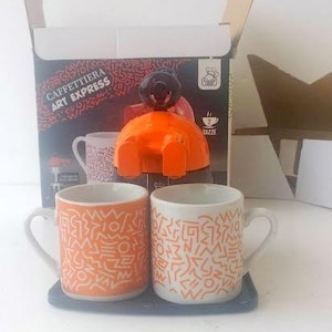machine à expresso italienne vintage, cafetière à expresso pour deux portions sur la cuisinière, plus deux tasses en porcelaine, machine à expresso double dose