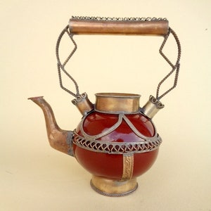 Teiera marocchina con bicchieri da tè colorati su stoffa fantasia creata  con ai generativa