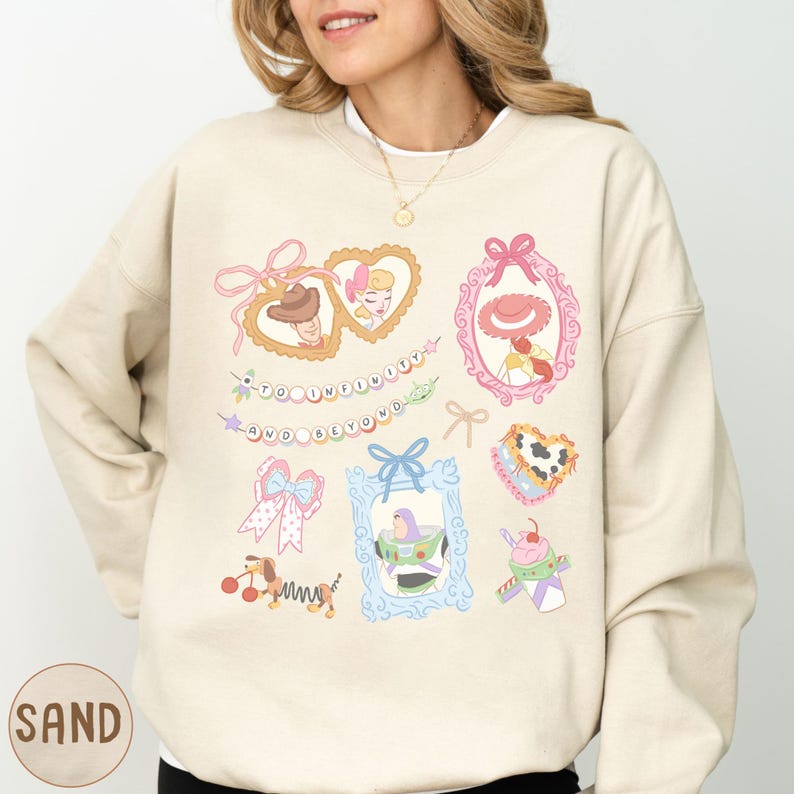 A woman wearing a beige sweater with various cartoon-style illustrations and text on it.