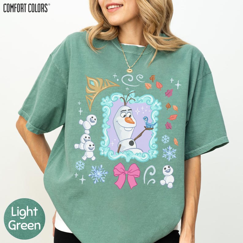 A woman wearing a green t-shirt with a graphic design featuring characters from the Disney movie Frozen.