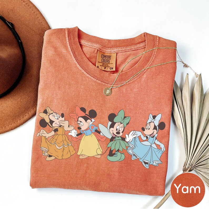 a red t-shirt with a cartoon character design, a hat, a necklace, and a fan.