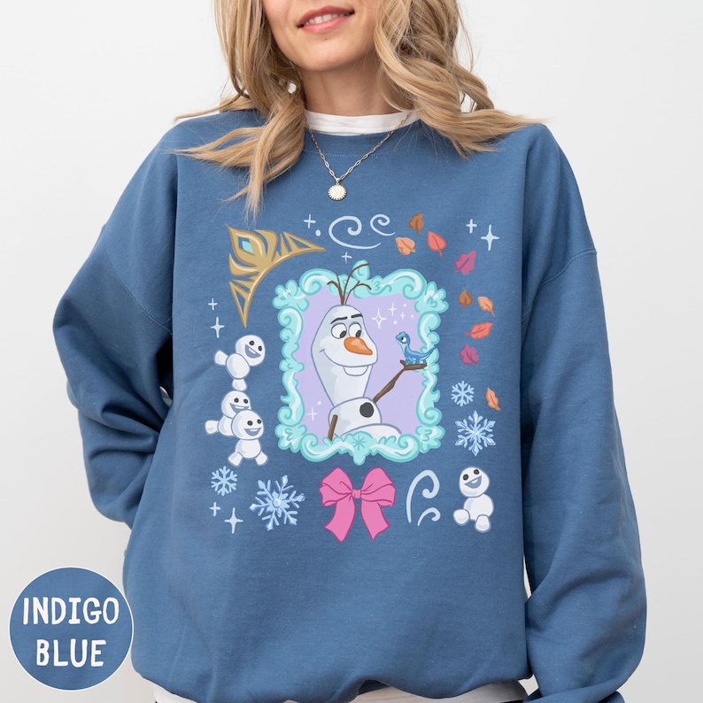 A woman wearing a blue sweatshirt with a colorful graphic design featuring characters from the Disney movie Frozen.
