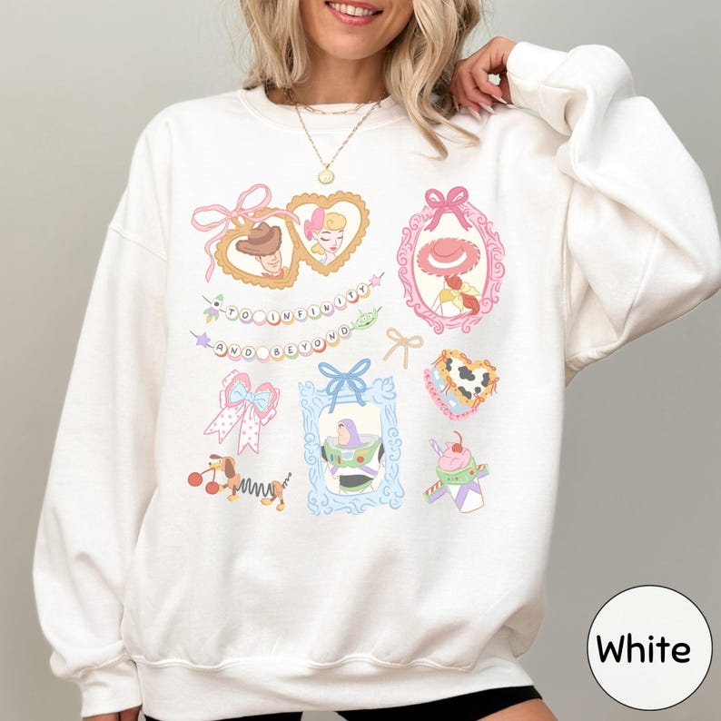 A woman wearing a white sweatshirt with various colorful illustrations and text on it.