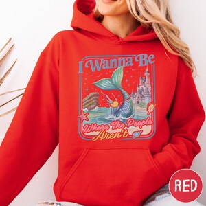 A woman wearing a red hoodie with a graphic design on it.