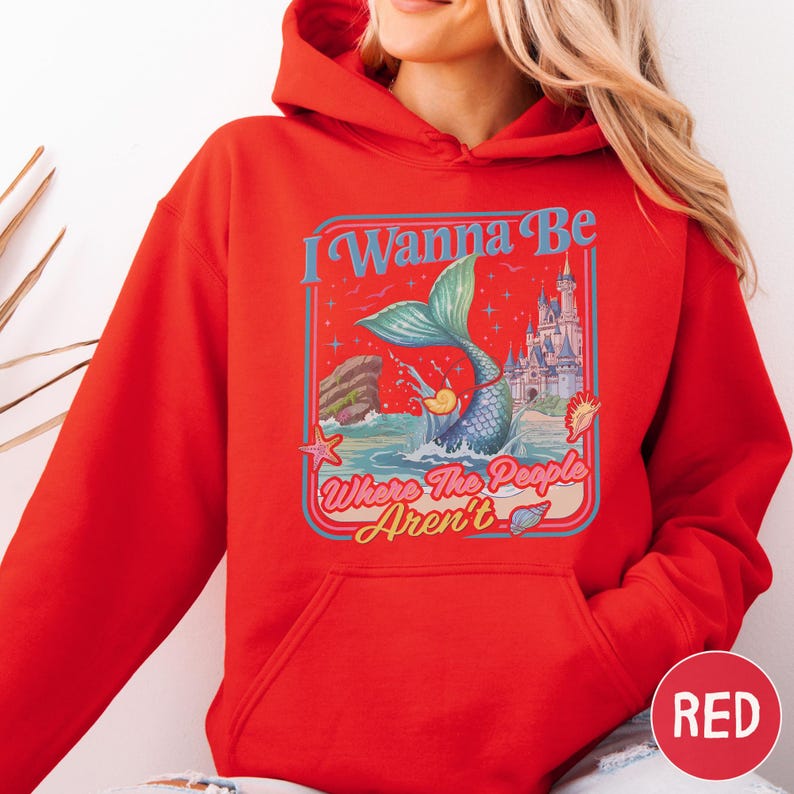 A woman wearing a red hoodie with a graphic design on it.