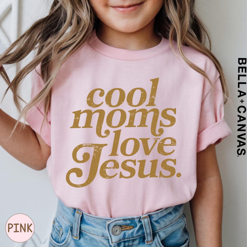 A young girl wearing a pink t-shirt with the text "cool moms love Jesus" printed on it.