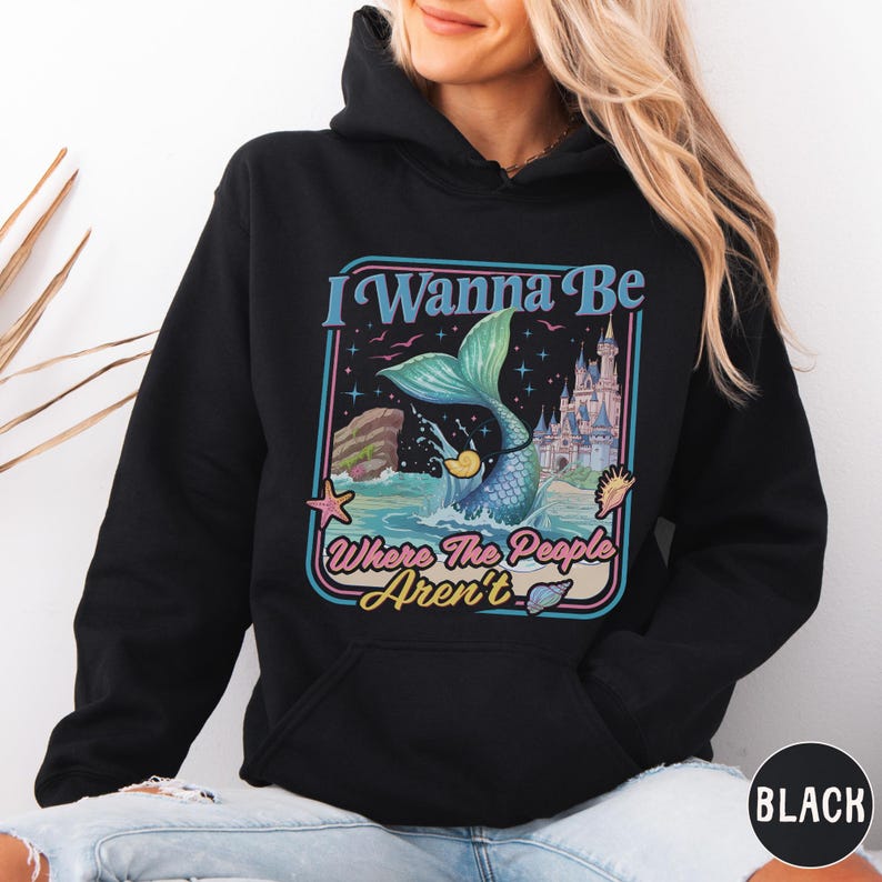 A woman wearing a black hoodie with a colorful graphic design on it.