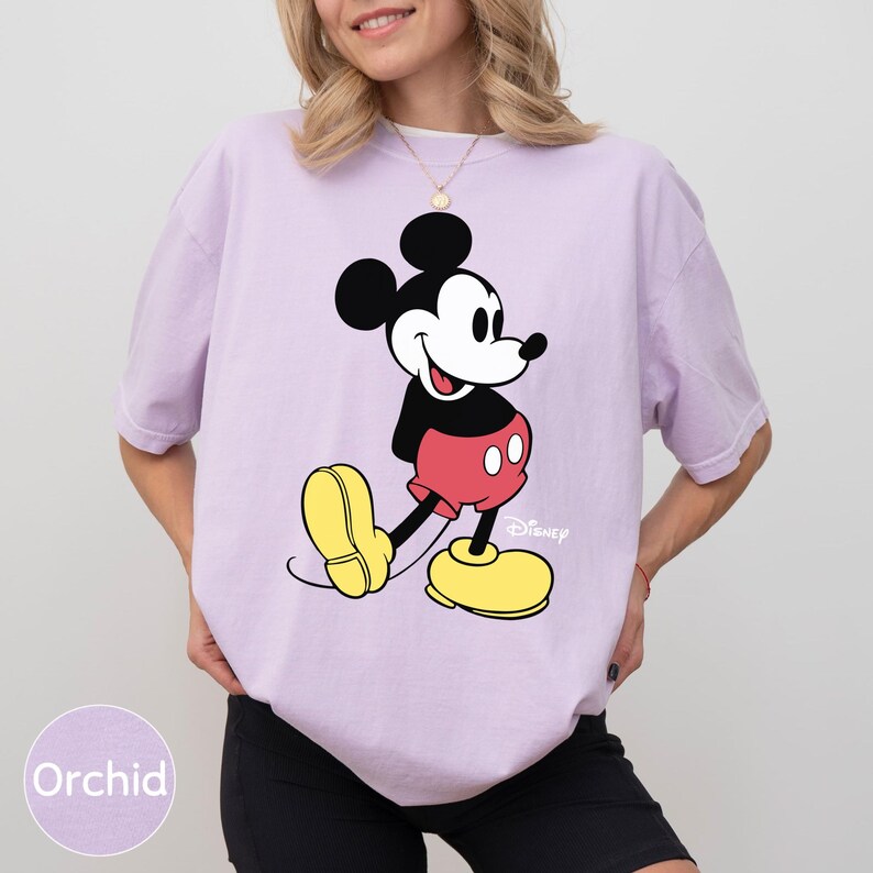 A woman wearing a purple t-shirt with a Mickey Mouse graphic printed on it.