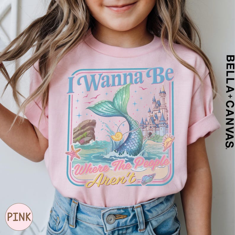 A young girl wearing a pink t-shirt with a mermaid graphic and text that says "I Wanna Be Where The People Aren't".