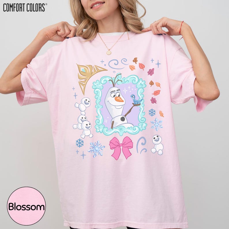A woman wearing a pink t-shirt with a design featuring characters from the Disney movie Frozen.