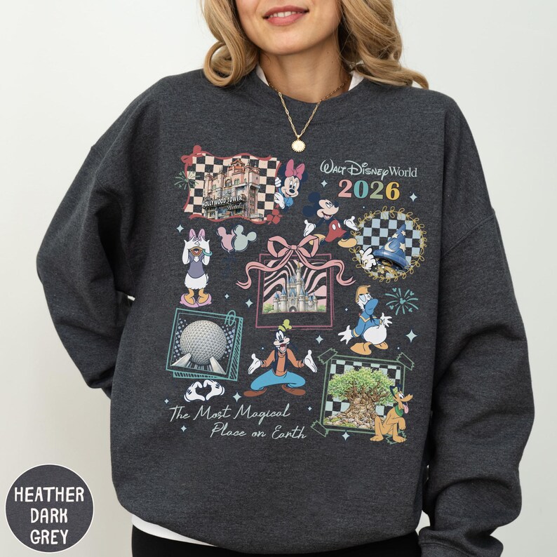 A woman wearing a gray sweatshirt with a collage of Disney-themed illustrations and text.