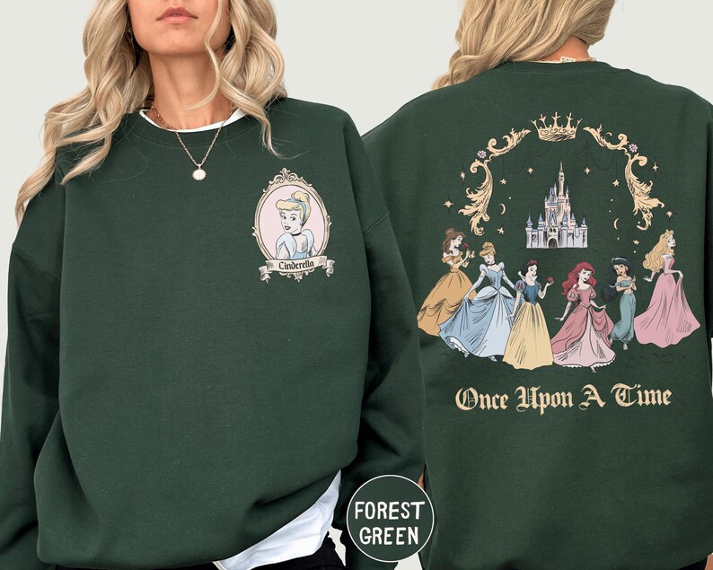A woman wearing a green sweatshirt with a Disney princess design on the front and back.