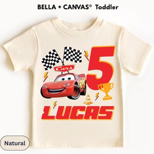 A white t-shirt with a design featuring a red race car and checkered flags, along with the text "Lucas" and the number "5".