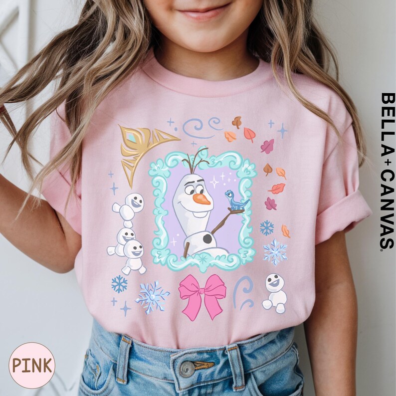 A young girl wearing a pink t-shirt with a graphic design featuring characters from the Disney movie Frozen.