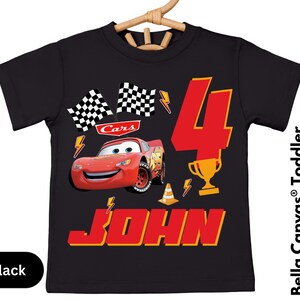 A black t-shirt with a design featuring a red car and the number 4, along with the text "Cars 4 JOHN".