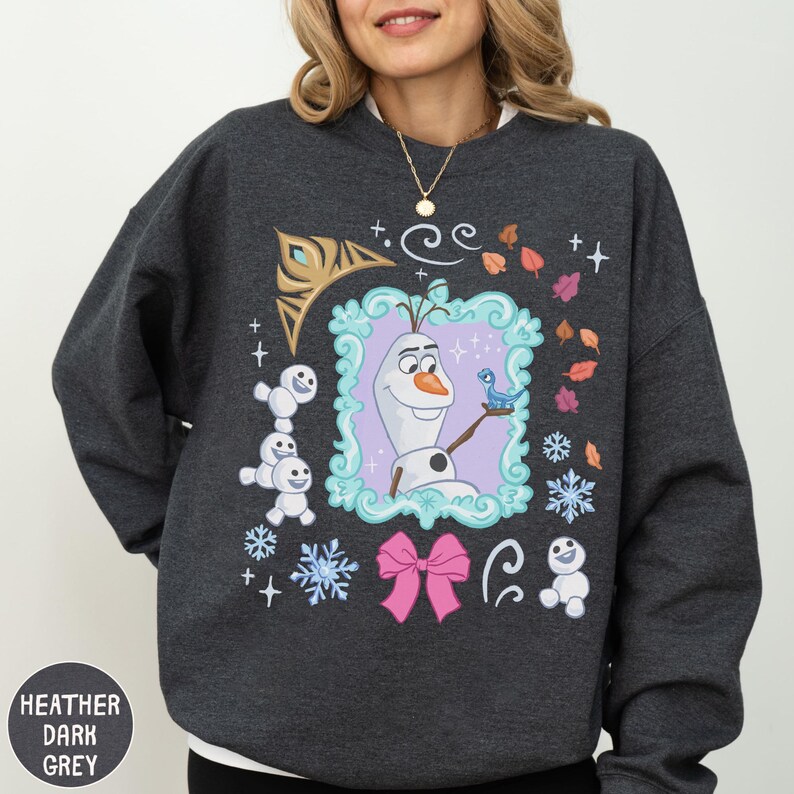 A woman wearing a gray sweatshirt with a colorful graphic design featuring characters from the Disney movie Frozen.